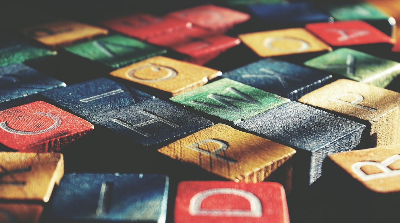 Vintage-style close-up of colorful wooden alphabet blocks creating an artistic pattern.
